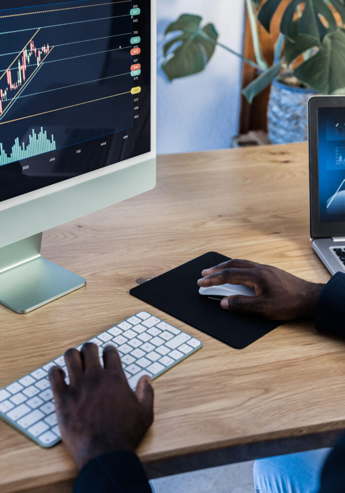 African trader studying stock market at home - Focus on computer screen