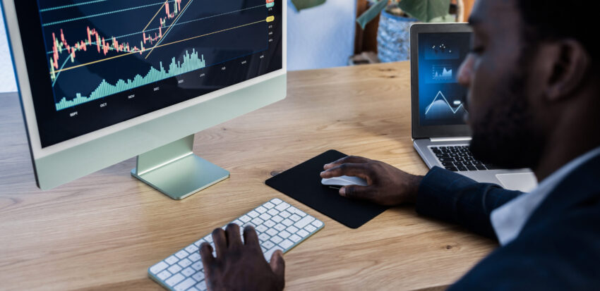 African trader studying stock market at home - Focus on computer screen
