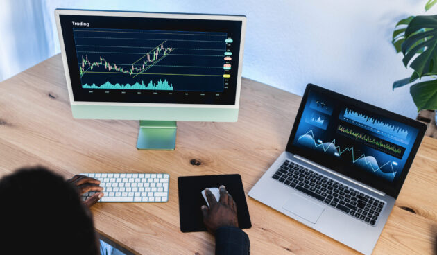 African trader studying stock market at home office - Focus on right hand