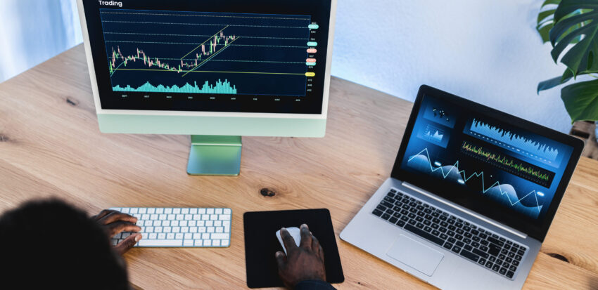 African trader studying stock market at home office - Focus on right hand