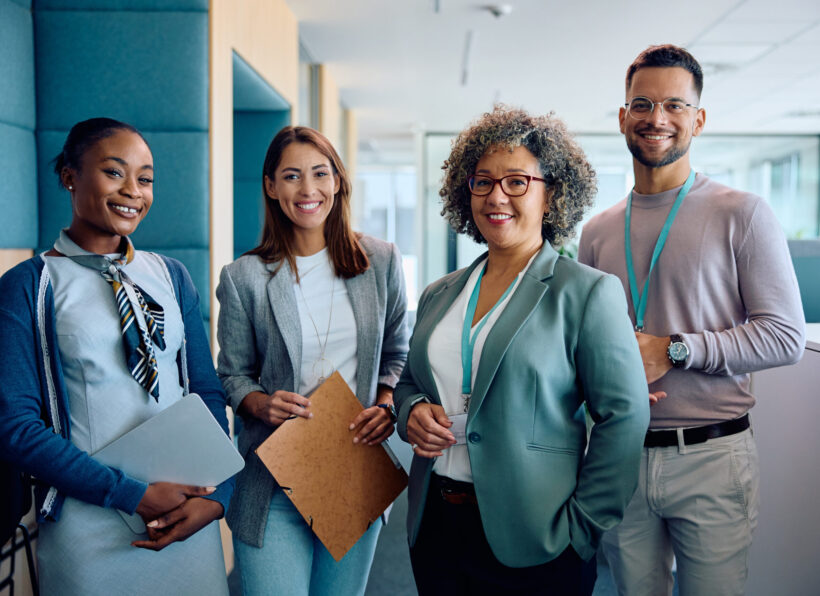 Group of happy entrepreneurs in business office looking at camera.