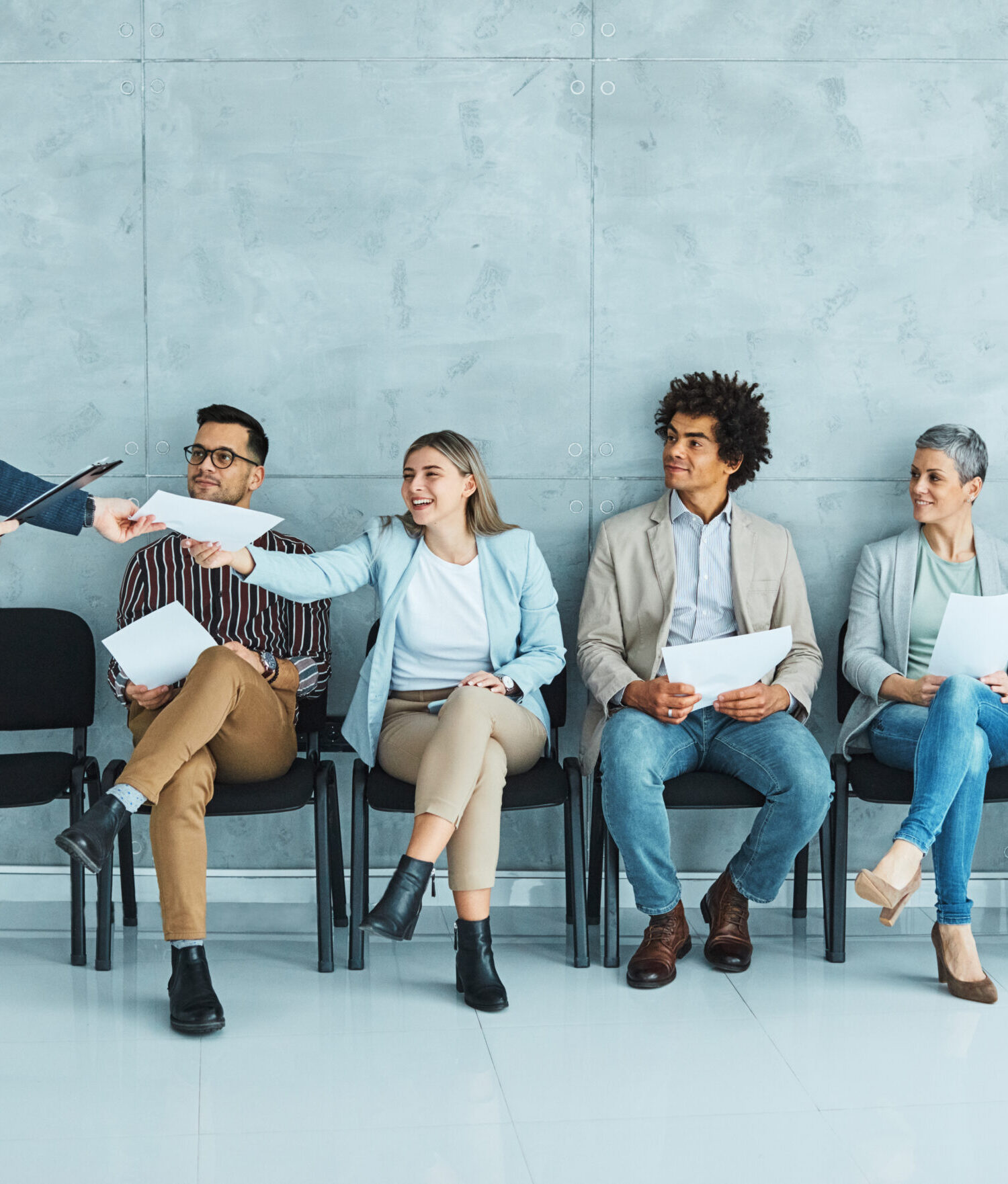 Group of young businss people sitting in chairs and waiting for an interview
