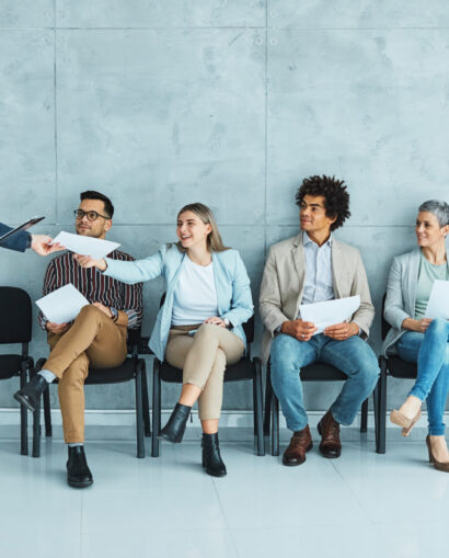 Group of young businss people sitting in chairs and waiting for an interview