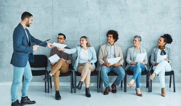 Group of young businss people sitting in chairs and waiting for an interview