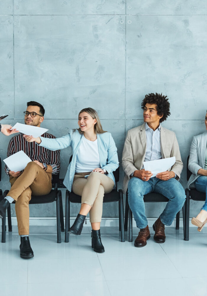 Group of young businss people sitting in chairs and waiting for an interview