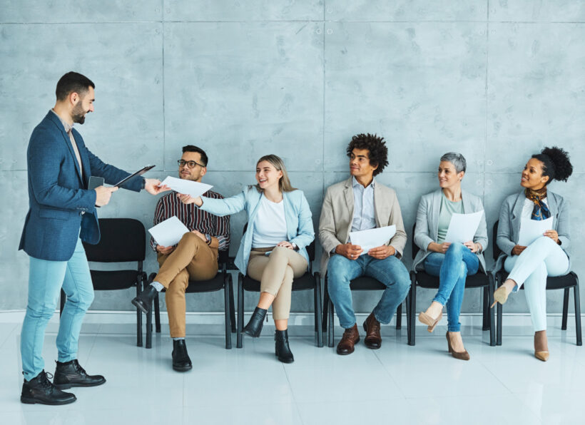 Group of young businss people sitting in chairs and waiting for an interview